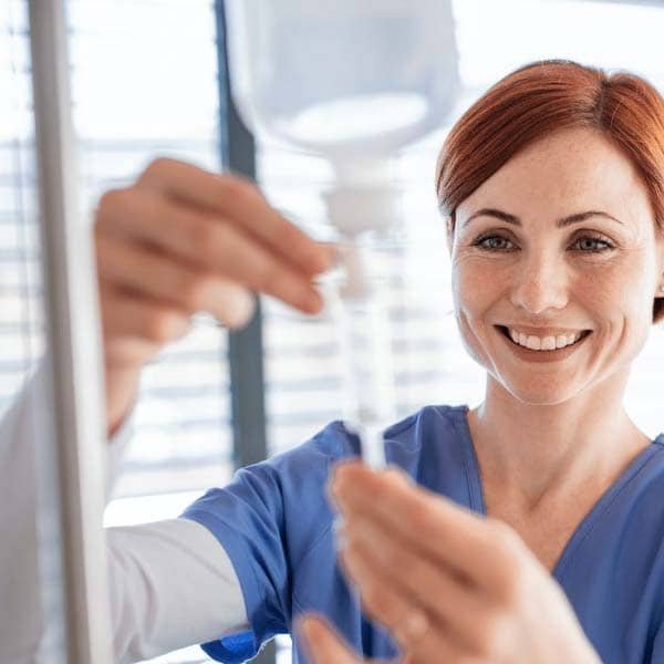 Healthcare professional preparing an intravenous infusion